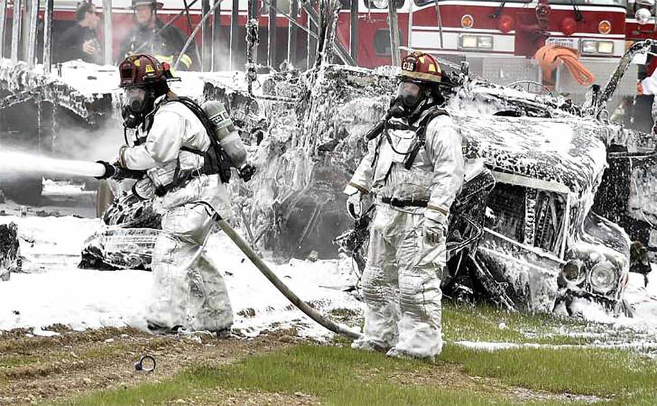 Members of the Wright Patterson fire department spray foam on a tractor trailer and car after they collided head-on and burst into flames April 14, 2015, on eastbound I-70 near the Enon Road entrance. The driver of the car, Christopher Coleman of Xenia, was killed in the crash but the truck driver escaped without injury. Bill Lackey/Staff