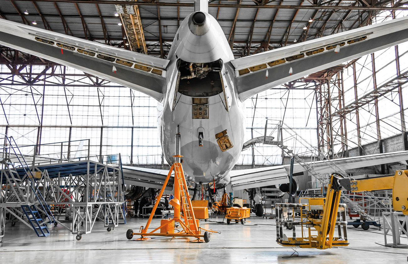 Aircraft in a hangar looking at an auxiliary power unit (APU).